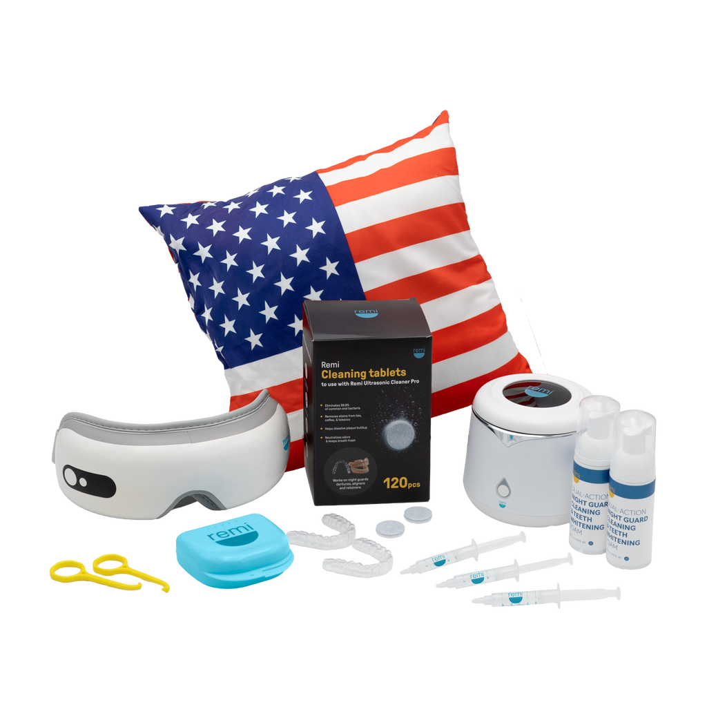 A collection of dental care products, including teeth whitening essentials, an eye mask, cleaning tablets, mouth trays, syringes, two spray bottles, a blue case, yellow tweezers, and a pillow with an American flag design.