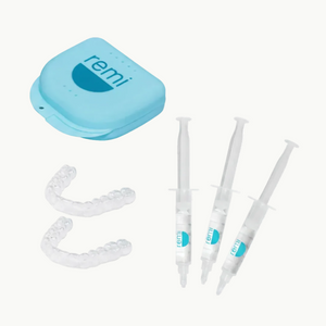 A light blue case labeled remi, two clear whitening trays, and three syringes with teeth whitening gel, arranged on a white background.