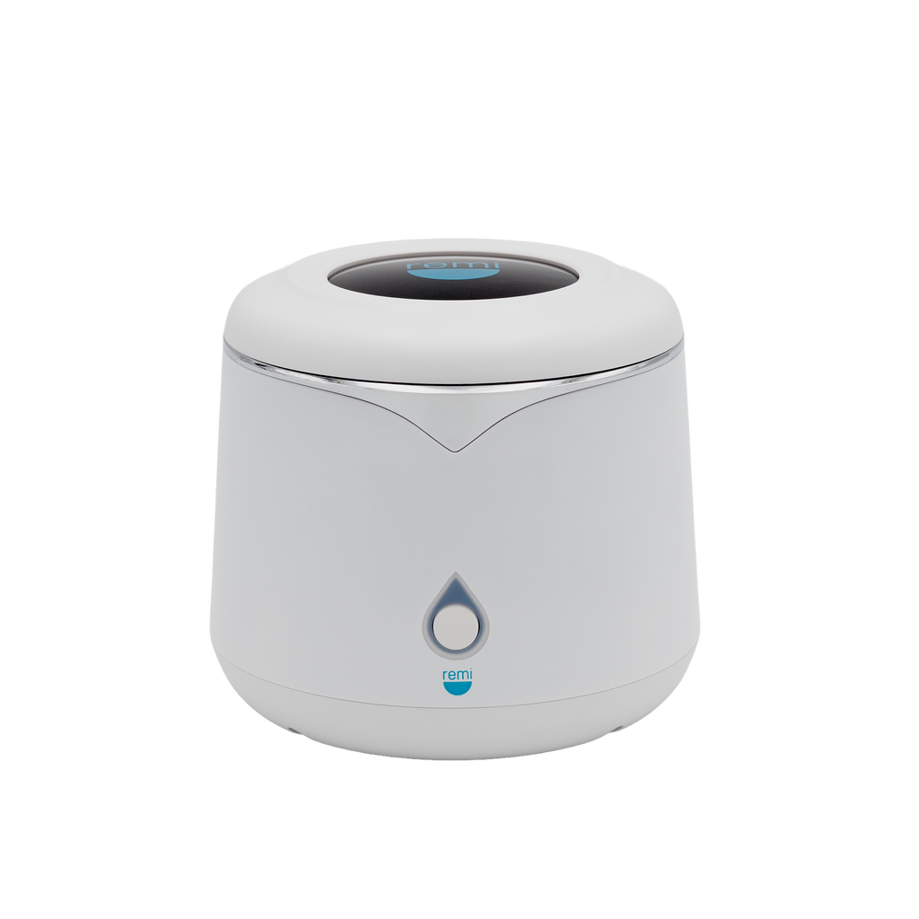 A white cylindrical device with a rounded top, featuring a teardrop-shaped button and a blue logo reading “remi” on the front. The device has a modern, minimalist design.