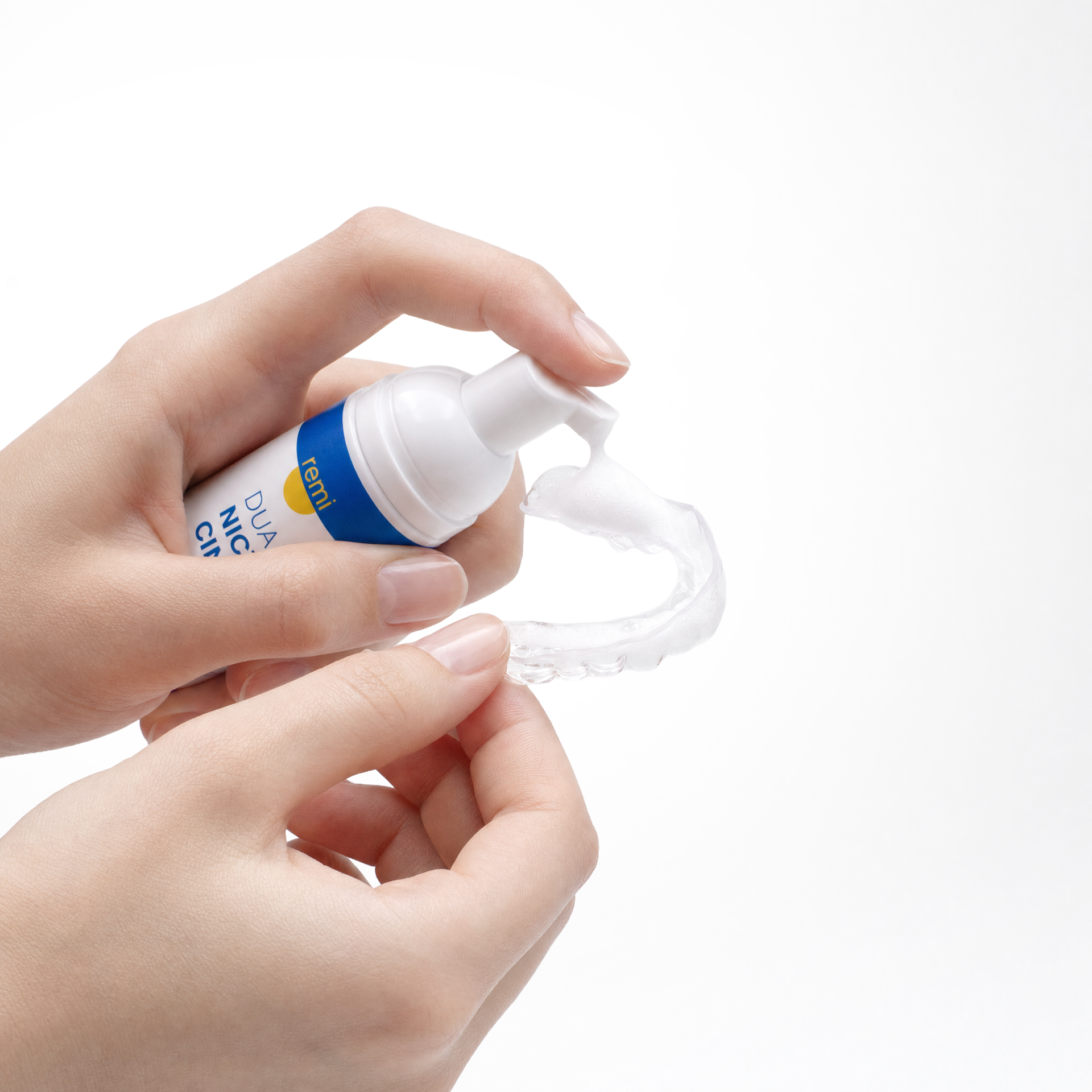 Pumping Remi whitening foam onto a night guard for daily cleaning