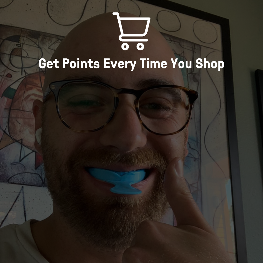 Man with a smile displaying a blue, tooth-shaped object on his tongue against an indoor background with text overlay that reads "get points every time you shop.