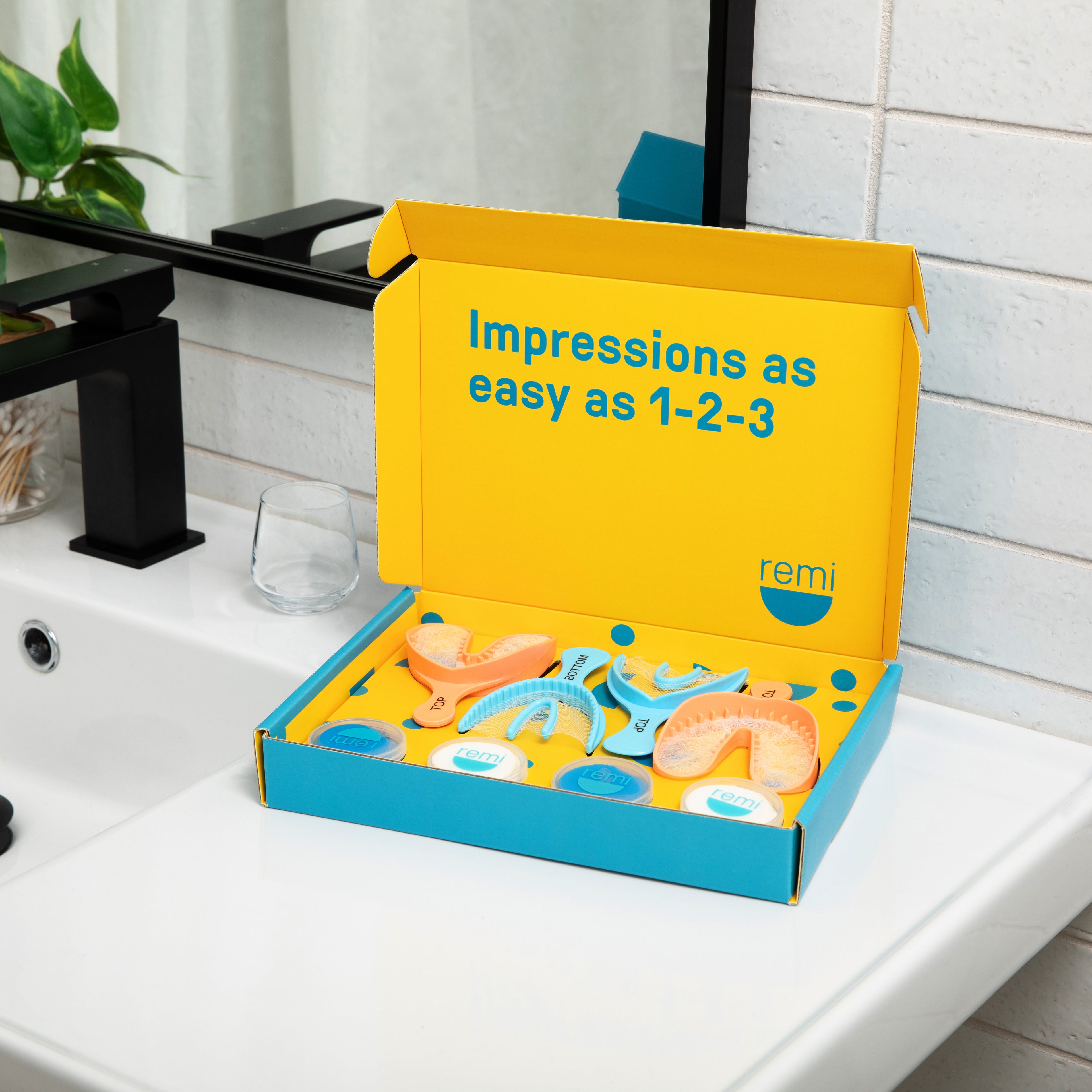 Yellow and blue box with dental impression tools on a bathroom counter