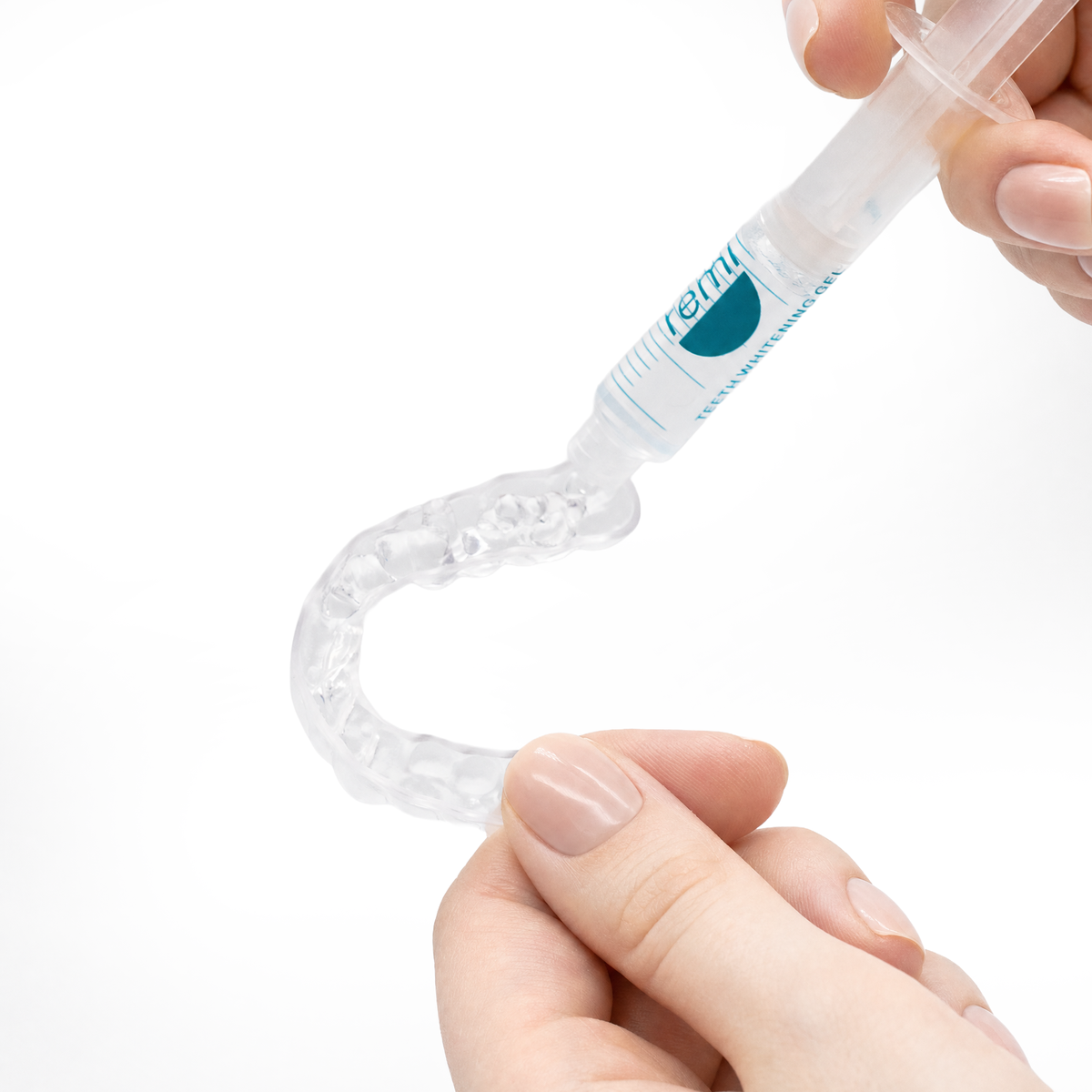 Applying Remi teeth whitening gel to a custom-fit whitening tray