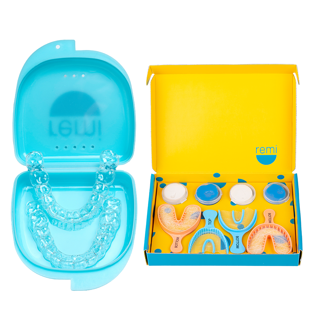 An open blue case with clear Custom Night Guards sits beside a yellow box containing dental impression trays and materials, showcasing dental-grade quality ideal for those seeking relief from teeth grinding.