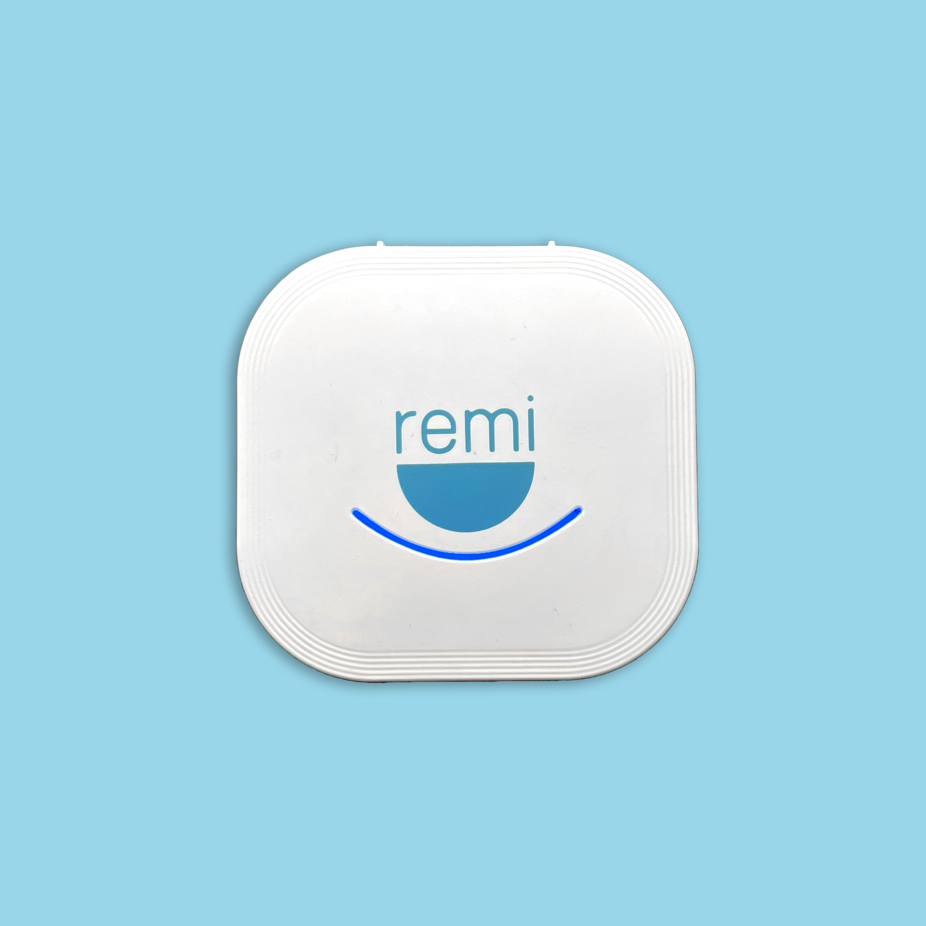 A white square device with rounded corners on a blue background. The device, part of the Ultimate Teeth Whitening Bundle, features the logo "remi" above a blue semicircle, emphasizing its focus on advanced oral hygiene and teeth whitening.